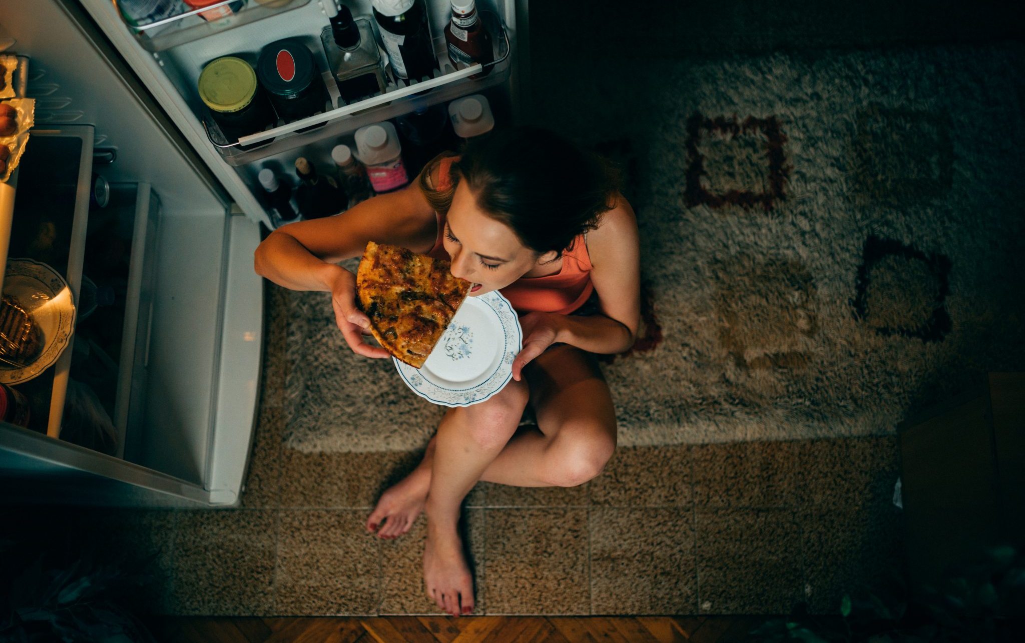 woman eating pizza at night